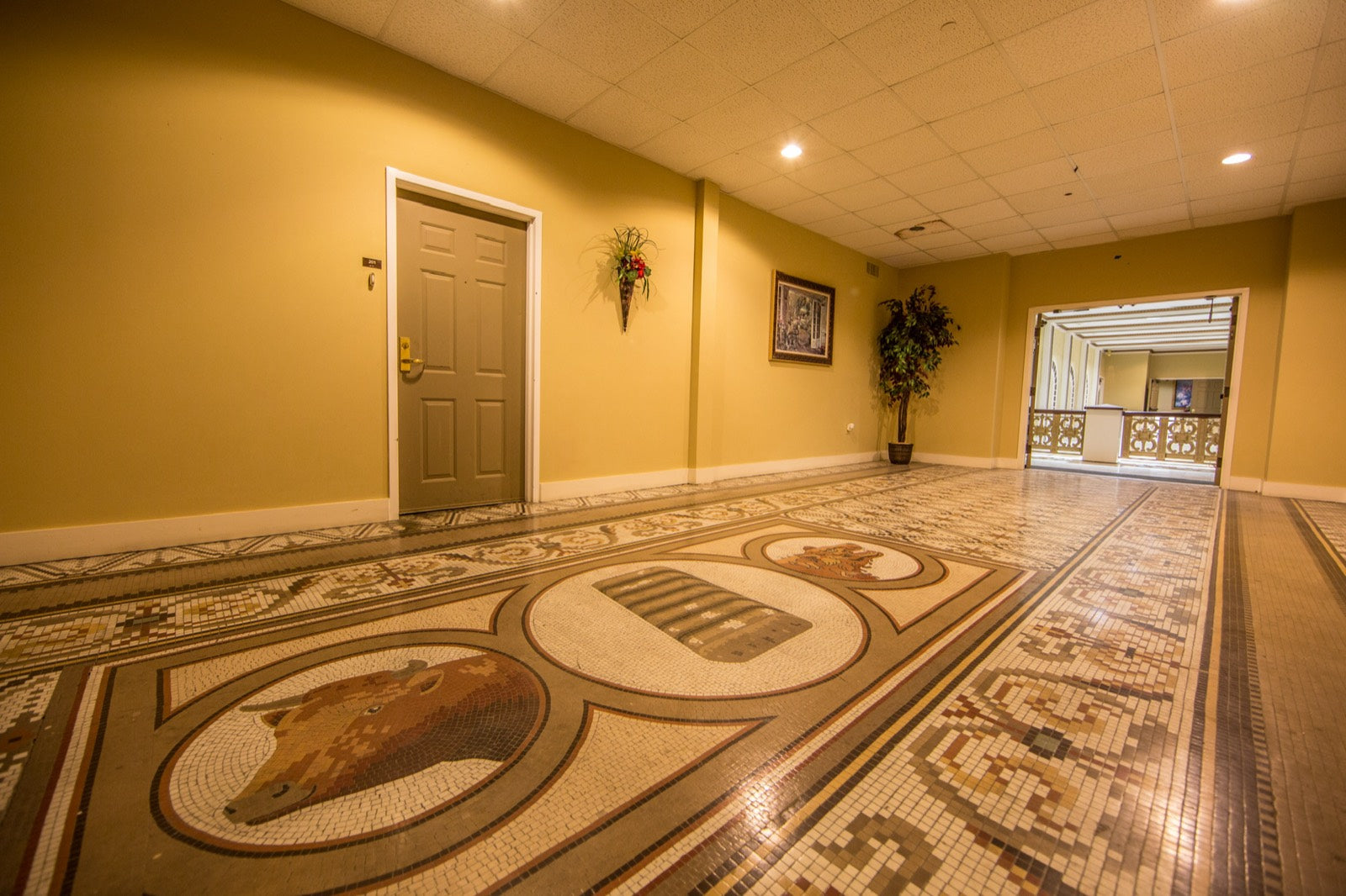 Restored mosaic-tile corridor with floor medallion inside the Exchange Building