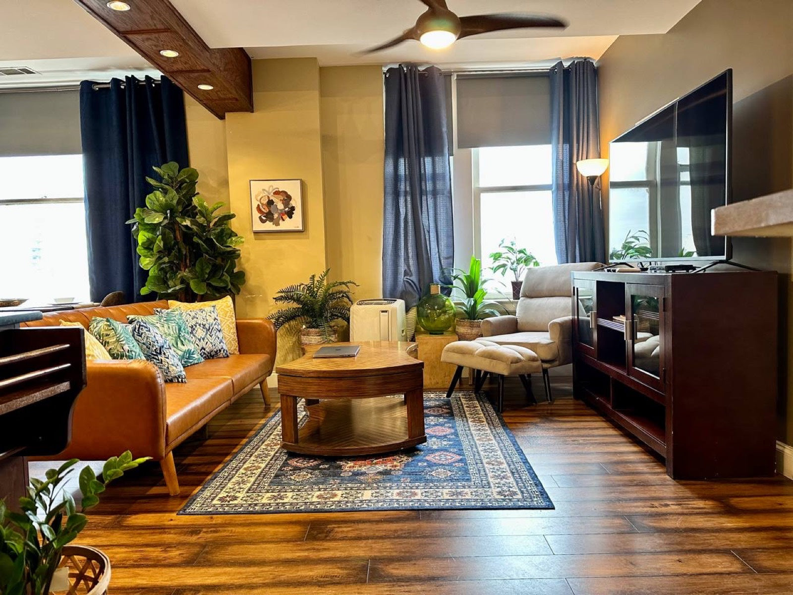 Furnished living room with leather sofa, houseplants and a blue rug, Exchange Building Memphis