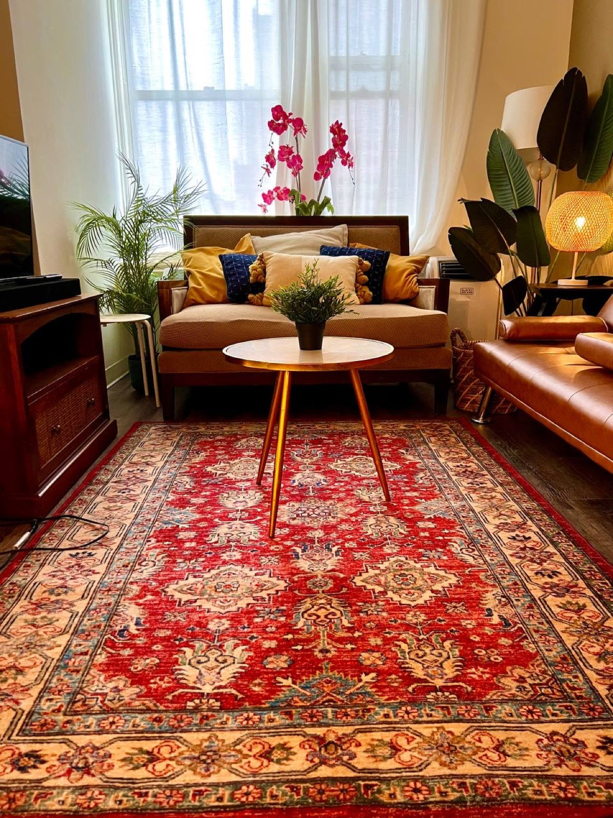 Furnished apartment living room with a red Persian rug at the Exchange Building, Downtown Memphis