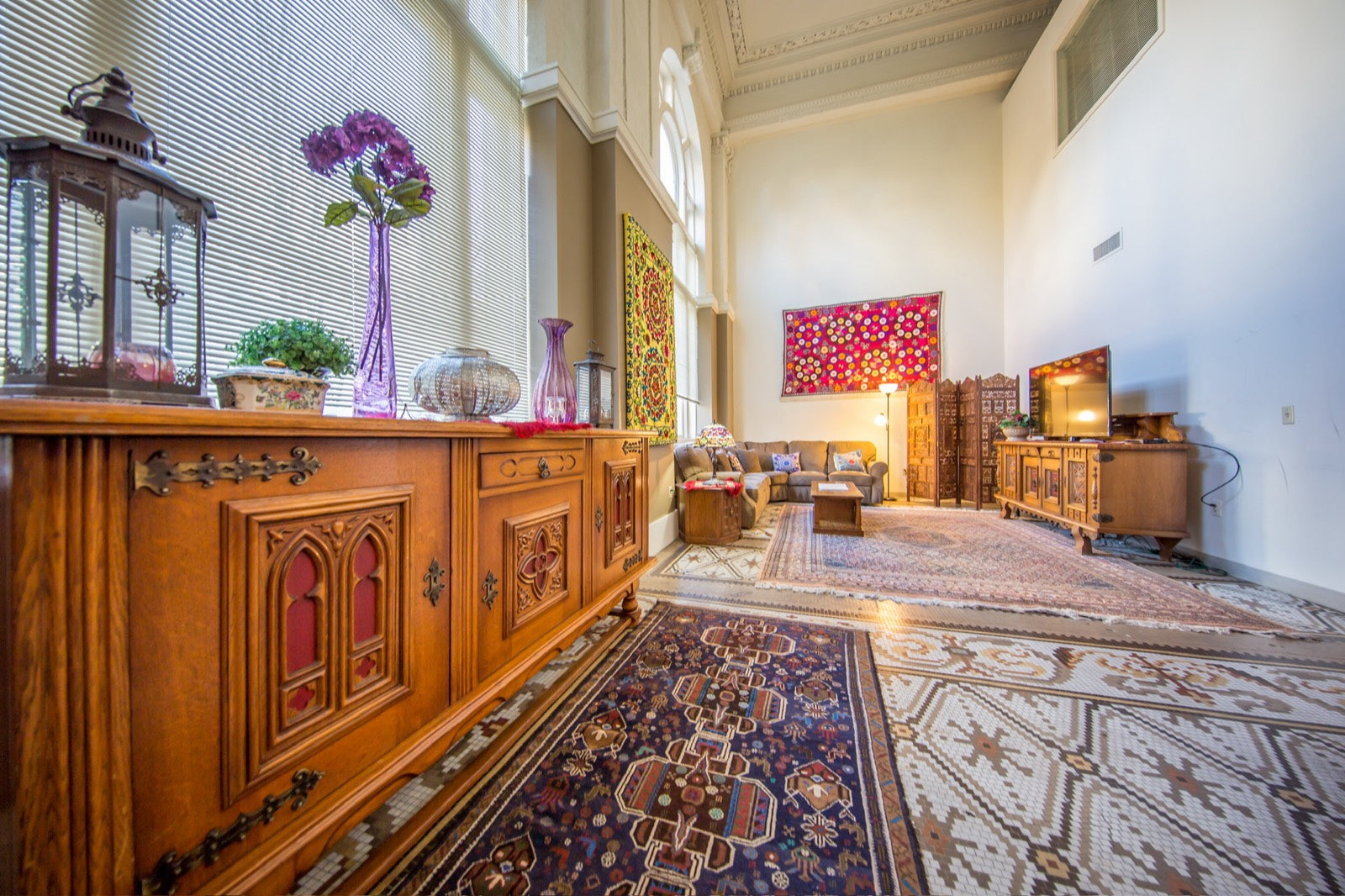 Furnished living room with antique carved sideboard and Uzbek suzani textiles, Exchange Building Memphis