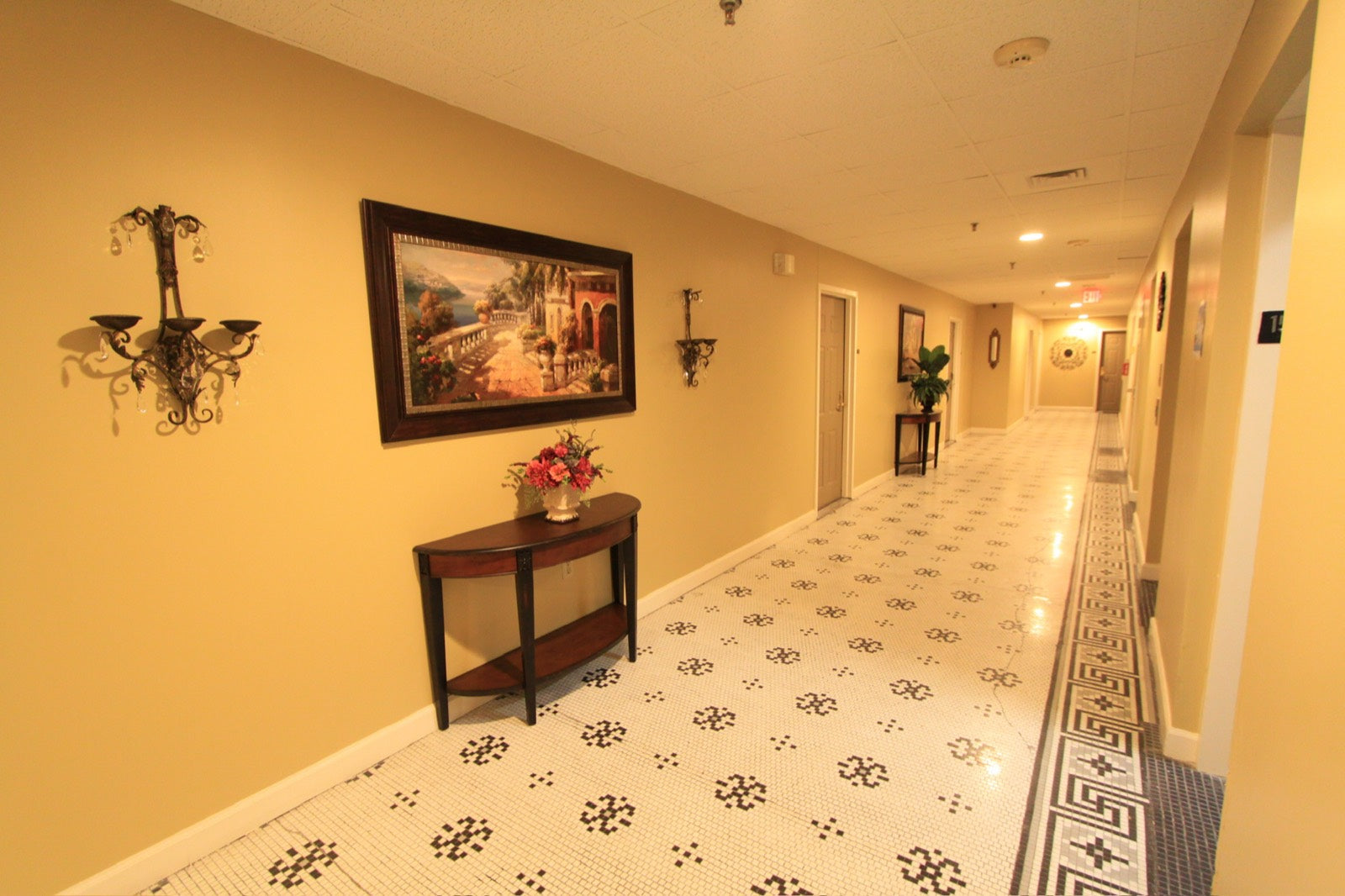 Elegant residential hallway with period sconces and mosaic floor, Exchange Building Memphis