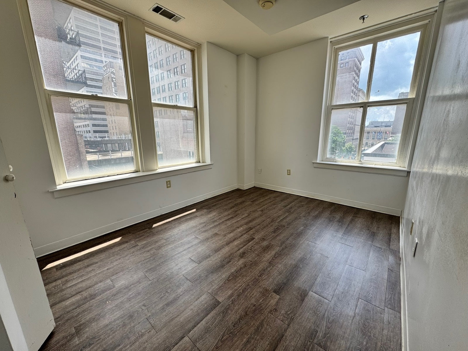 Unfurnished corner apartment framed by tall historic windows, Exchange Building Memphis