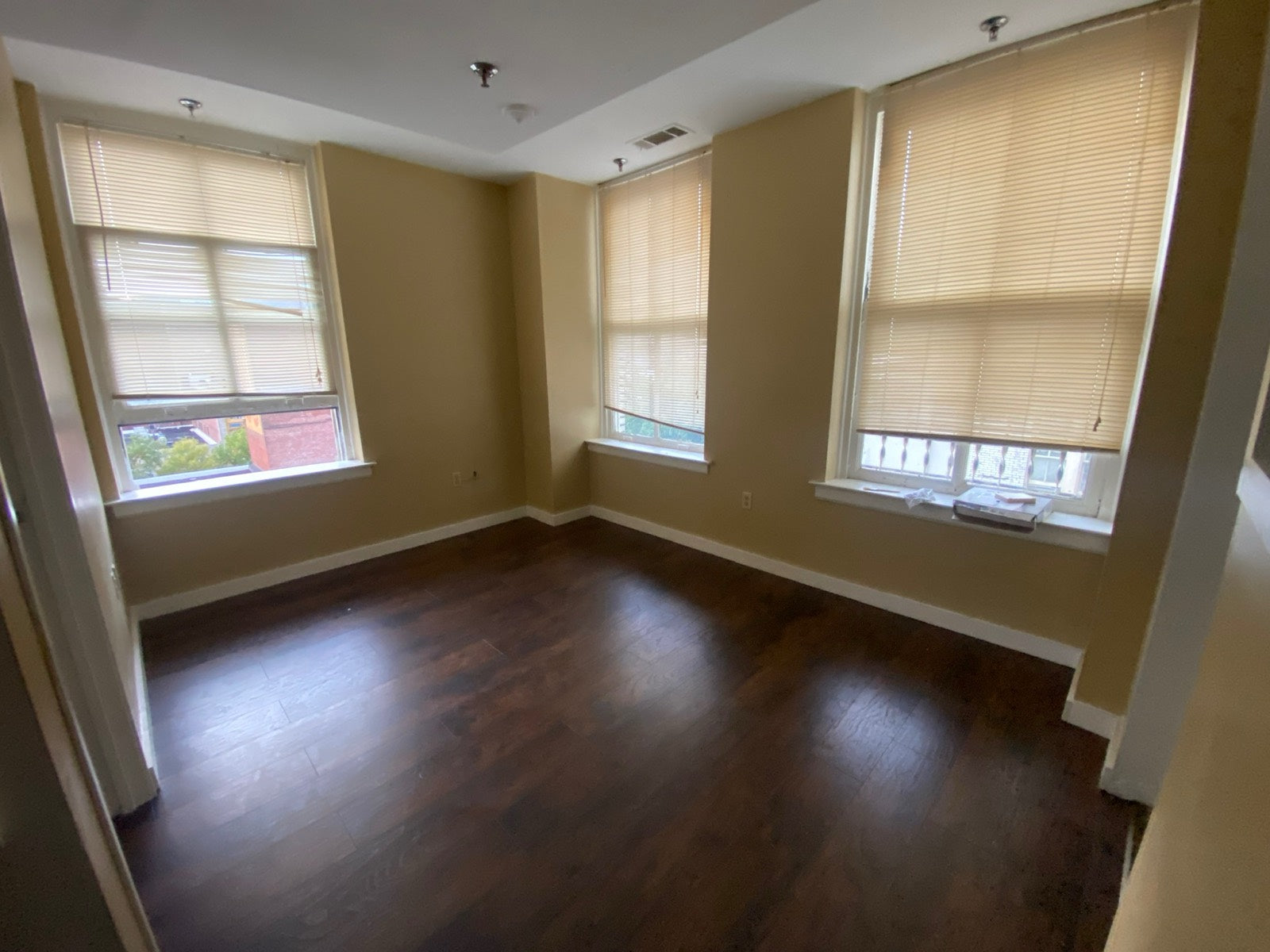 Unfurnished apartment with three light-filled windows and wood floors, Exchange Building Memphis